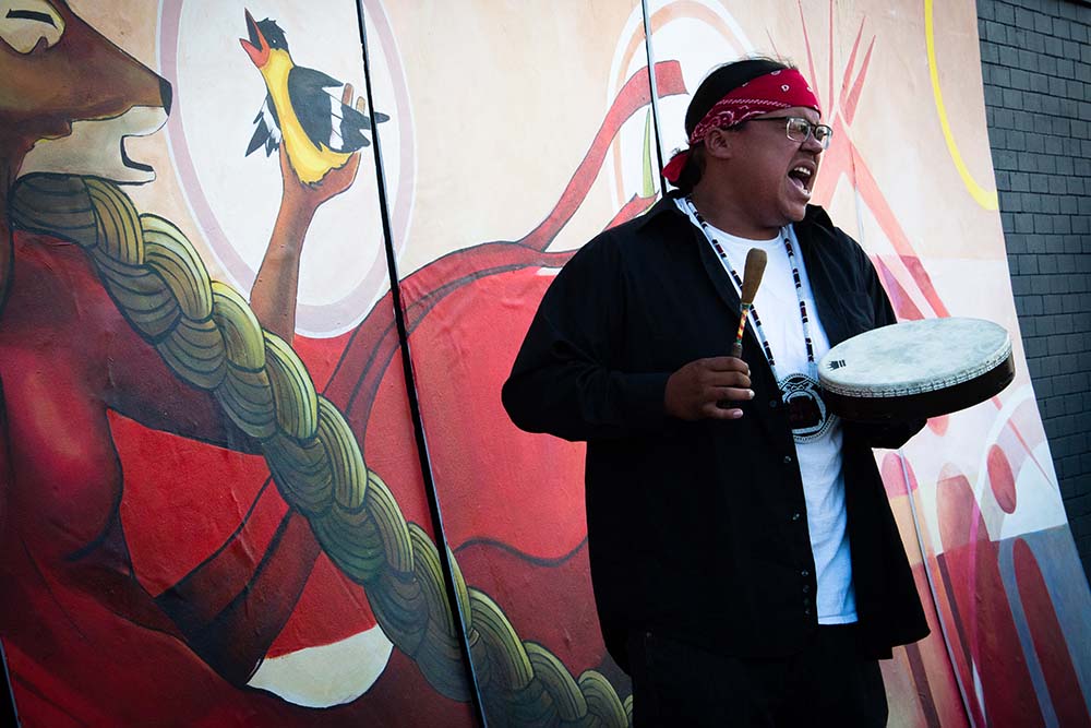 Landon on hand drum at mural unveiling. Photo Cedite Ivy Vainio